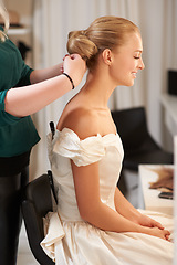 Image showing Hairdresser, wedding and woman styling for long, healthy and bridal hairstyle on a young model. Stylist, beauty and beautiful female person from Australia at salon or spa for self care treatment.