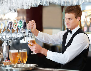 Image showing Man, bartender and waiter with beer at pub, restaurant or event for happy hour, hospitality industry or customer service. Young barman, server or catering employee with alcohol drinks in glasses