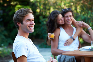 Image showing Young man, laughing and friends in a backyard at home with bbq and happy event by a table. Group, teenager and lunch with people together in a summer in a garden with a smile and food for outdoor