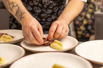 Image showing Chef arranging piece of meat