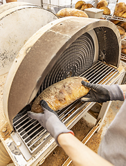 Image showing Worker grate bread crust in factory