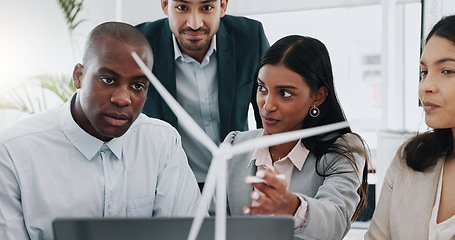 Image showing Business people, windmill model and team in office, woman and laptop for innovation, energy and sustainability. Engineering consultant, group and brainstorming with wind power for clean electricity