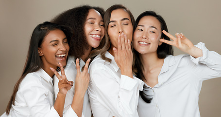 Image showing Diversity, peace sign and group of women in studio for empowerment, wellness and community. Emoji, friends and people hug, blow kiss and smile for beauty, inclusion and support on brown background