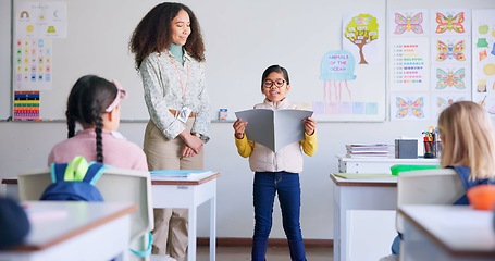 Image showing Student, child and reading a book in class for learning, development and communication. A boy kid and teacher woman teaching language, support and assessment in elementary classroom at school