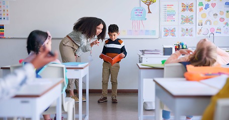 Image showing Teacher, child and reading a book in class for learning, development and communication. A boy kid or student and woman teaching language, support and assessment in elementary classroom at school