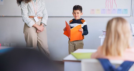 Image showing Child, student and reading a book in class for learning, development and communication. Boy kid and woman teacher for language, support and assessment or confidence in elementary classroom at school