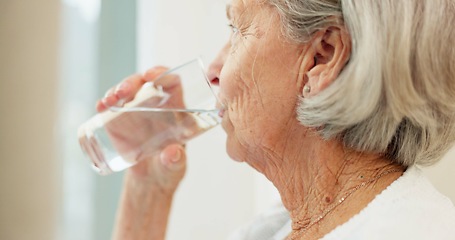 Image showing Healthy, hydration and senior woman drinking water for wellness and liquid diet detox at home. Thirsty, fresh and calm elderly female person enjoying glass of cold drink in modern retirement house.