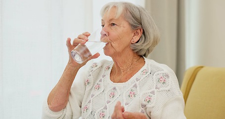 Image showing Water, pills and senior woman on a sofa with medicine for health, balance and aging wellness in her home. Tablet, swallow and elderly lady in living room with vitamin c, collagen or iron and calcium