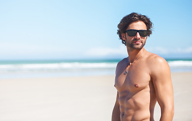 Image showing Summer, space and the body of a man on the beach for travel, relax or adventure on vacation. Sand, sunglasses and a young person shirtless by the ocean or sea on a tropical coast for holiday