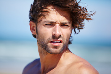 Image showing Face, idea and wind with a man on the beach for freedom, travel or vacation in summer. Nature, thinking and wellness with a shirtless young person at peace on the coast for a tropical holiday