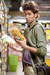 Image showing Man, portrait and product comparison in supermarket question, choice or label difference. Male person, thinking and nutrition value for grocery shopping decision, wholesale price or discount search