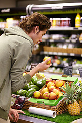 Image showing Man, choice and fruit, grocery shopping and store with fresh produce, retail and customer look at product. Groceries, food and nutrition, back or buying with decision, market and client in shop