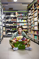 Image showing Man, grocery shopping and shop, stress about inflation and expensive food, overwhelmed in supermarket. Groceries in basket, retail and customer shocked by price, choice and purchase with fear