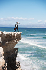 Image showing Thinking, cliff and business man on edge by ocean for opportunity, problem solving and solution. Professional, bankruptcy and confused corporate worker on rocks for danger, risk and fail in company