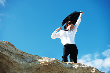 Image showing Cliff, business and man with celebration, excited and victory with holiday, smile and winning with promotion. Person, employee and consultant outdoor, nature and vacation with achievement or travel