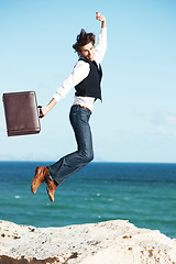 Image showing Portrait, ocean and jump with man, briefcase and achievement with happiness, celebration and business. Person, employee and consultant with seaside background, beach and action with vacation or break