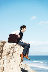 Image showing Thinking, cliff and business man sitting by ocean for freedom, opportunity and career in nature. Professional, mockup and corporate worker on rocks edge for work challenge, ideas and future goals