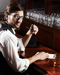 Image showing Portrait, writer and man with a notebook, whiskey and creativity with inspiration, journalist and glasses. Face, person and author with alcohol, ideas and writing in a tavern, poet and freelancer