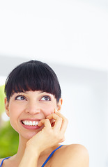 Image showing Happy, smile and young woman at her home with positive, good and confident attitude or mindset. Happiness, excited and female person from Canada biting her nail and thinking in her modern house.