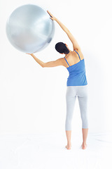 Image showing Woman, exercise or ball with back for yoga, exercise or workout on muscle, posture and healthy body. Person, arm or stretching for pilates, training or fitness with sportswear and technique in studio