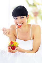 Image showing Fruit salad, home bed and portrait of happy woman with organic meal, snack or morning breakfast for healthy lifestyle balance. Apartment bedroom, strawberry benefits or relax person eating vegan food