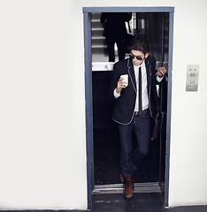 Image showing Coffee, fashion and young man in a doorway with stylish, cool or formal classy outfit with confidence. Latte, style and male person from Canada with elegant jeans and blazer in a office building.