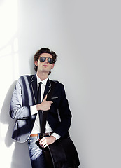 Image showing Fashion, elegant and handsome man by a wall with stylish, cool and trendy outfit and briefcase. Sunglasses, bag and young male model from Canada with formal and classy style by white background.