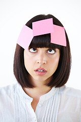 Image showing Stress, sticky note and the head of a business woman in studio isolated on a white background with a to do list. Face, thinking and confused with a young employee in doubt about a task closeup