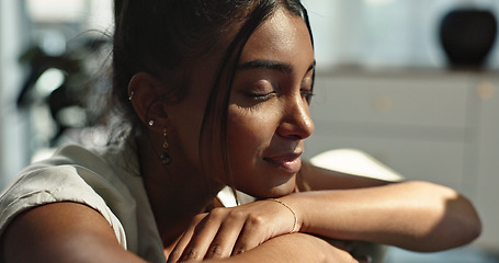 Image showing Thinking, calm and young woman on a sofa relaxing with an idea or memory in living room. Peace, smile and happy Indian female person chilling in the lounge of modern apartment for breathing.