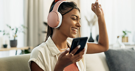 Image showing Phone, music and happy woman dance on sofa in home, singing and listening to audio. Smartphone, excited Indian person on headphones and radio, sound or freedom in living room on mobile app technology