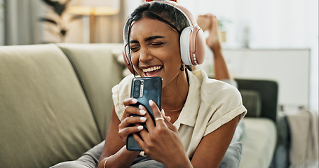 Image showing Woman, singing and phone with headphones on sofa, smile or relax for comic performance in living room. Girl, smartphone and audio streaming subscription with voice, noise or karaoke on couch in house