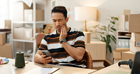 Image showing Man, phone and toothache in pain at office for e commerce, distribution or logistics business. Asian person, mobile app or searching for medical care by reading on internet, website or online at work