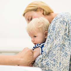 Image showing Child beeing vaccinated by pediatrician in presence of his mother. Preventive vaccination against Diphtheria, whooping cough, tetanus, hepatitis, haemophilus influenzae, pneumococcus, poliomyelitis