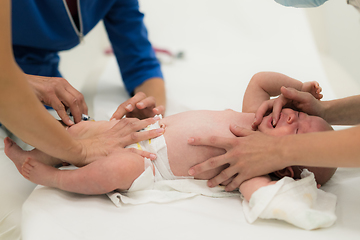 Image showing Baby beeing vaccinated by pediatrician in presence of his mother. Preventive vaccination against Diphtheria, whooping cough, tetanus, hepatitis, haemophilus influenzae, pneumococcus, poliomyelitis