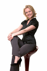 Image showing Smiling woman sitting on stool