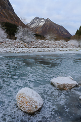 Image showing frozen river with sparkling stones in the foreground and sparkli