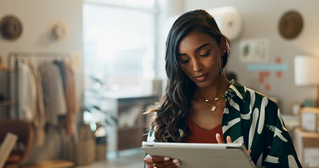 Image showing Woman, typing and tablet in small business for fashion, shipping and planning supply chan schedule. Reading, store reviews or employee in online shopping workshop with retail inventory or checklist