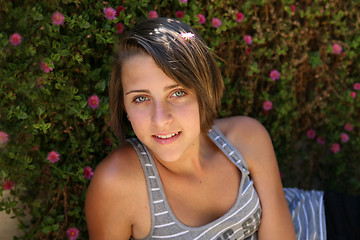 Image showing Beautiful teenage girl on background flowers