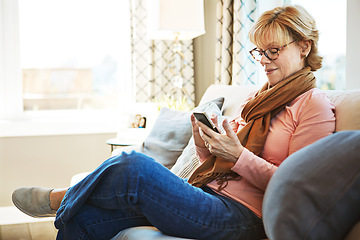 Image showing Home, phone or mature woman on social media with internet connection or website notification on sofa. Glasses, search or senior person texting on networking mobile app chat or reading news to relax