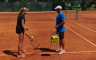 Image showing A professional tennis player and her coach training on a sunny day at the tennis court. Training and preparation of a professional tennis player