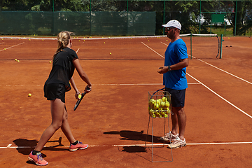 Image showing A professional tennis player and her coach training on a sunny day at the tennis court. Training and preparation of a professional tennis player