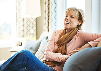 Image showing Thinking, laugh or mature woman on couch to relax with freedom on living room sofa at home. Funny joke, happy or senior person with smile, peace or wellness in retirement, lounge or house for resting