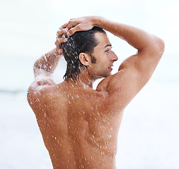 Image showing Shower, beach and man with water for cleaning, washing and grooming for healthy skin. Nature, treatment and back of person with splash for natural hygiene, wellness and skincare hydration outdoors