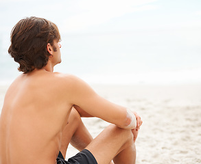 Image showing Man, thinking and sitting on beach sand relax for ocean summer air, vacation peace or sunshine travel. Male person, back view and thoughts or calm sea rest or water waves, outdoor or tropical island