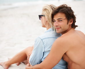 Image showing Couple, beach sand and sitting embrace on holiday vacation, sunshine lovers or sea salt hair. Man, portrait or woman relax for partnership connection or ocean view, romantic or summer tropical travel