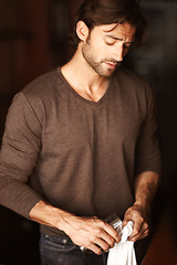 Image showing Bartender, man and polish glass in restaurant, cafe or small business to prepare in cafeteria. Cleaning, cloth and barman wipe cup, employee or professional waiter work in pub, coffee shop or service