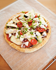 Image showing Healthy, vegan and pizza on table in kitchen, home or cooking with pita, cheese and tomato. Vegetable, flatbread and homemade food from Italy with nutrition in diet, meal or lunch on counter in house