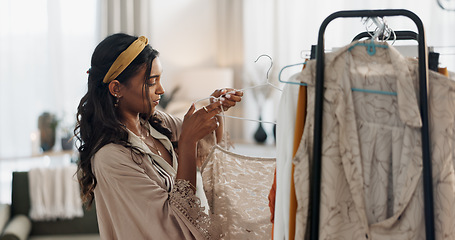 Image showing Woman, clothes rack and choice for fashion, retail management and small business in store or boutique. Young worker, entrepreneur or designer with stock, inventory and luxury dress or product on rail