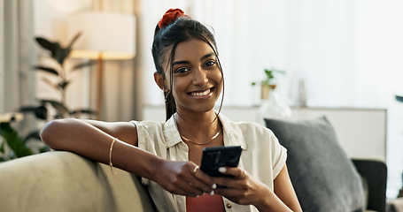 Image showing Woman, portrait and smile in home with cellphone, social media and update online subscription on sofa. Happy indian girl relax with smartphone app, download mobile games and chat to digital contact