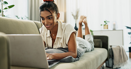 Image showing Woman, laptop and typing on sofa, relax and reading for search, thinking or e learning in home living room. Student, girl and computer on lounge couch, online course or happy for post on social media